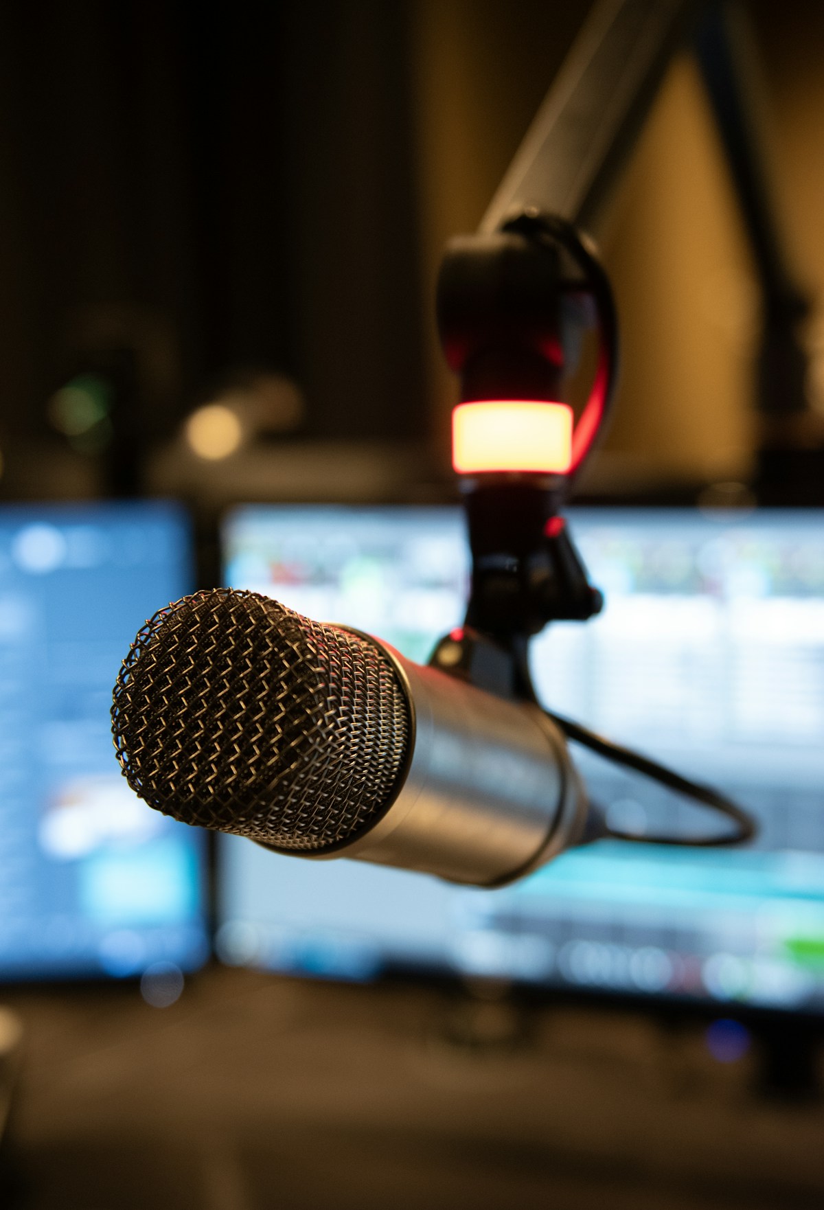 Studiomikrofon vor Monitoren – Symbolbild für Radio und Interviews